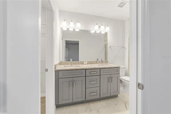 a bathroom with a double vanity sink and a mirror