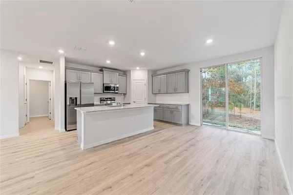 a view of kitchen with granite countertop stainless steel appliances counter space and wooden floor