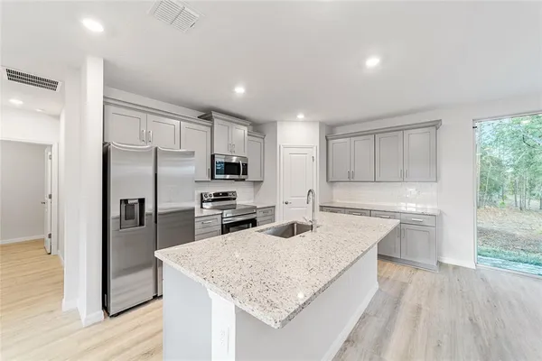 a kitchen with a center island appliances and cabinets