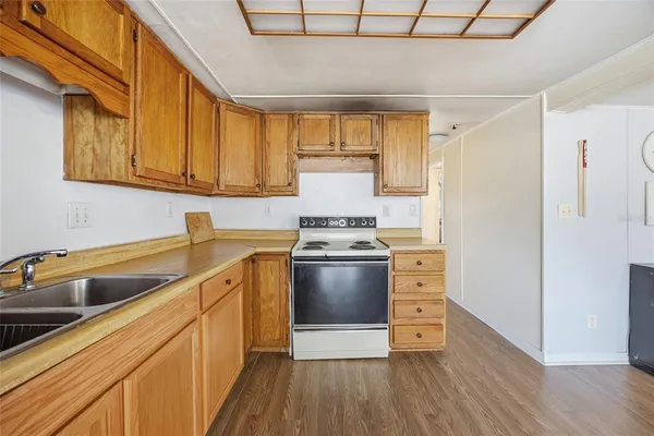 a kitchen with a stove cabinets and a wooden floor