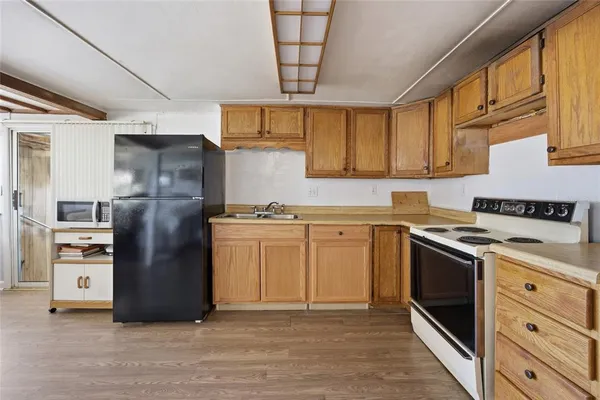 a kitchen with stainless steel appliances granite countertop a refrigerator a stove and a sink