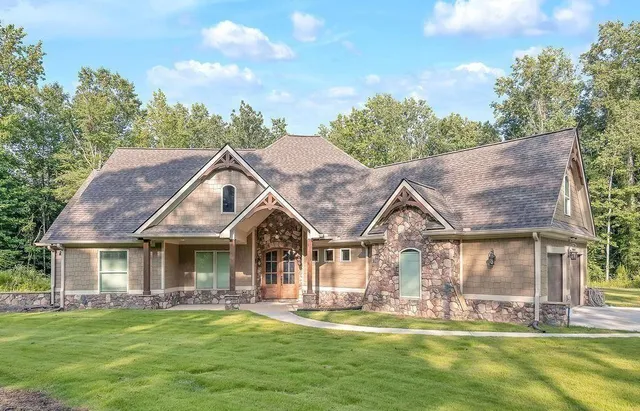 a front view of a house with a garden and trees