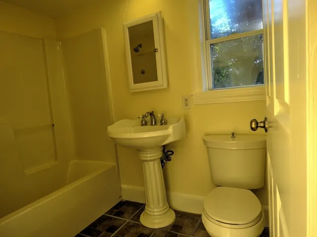 a bathroom with a sink a toilet and bathtub