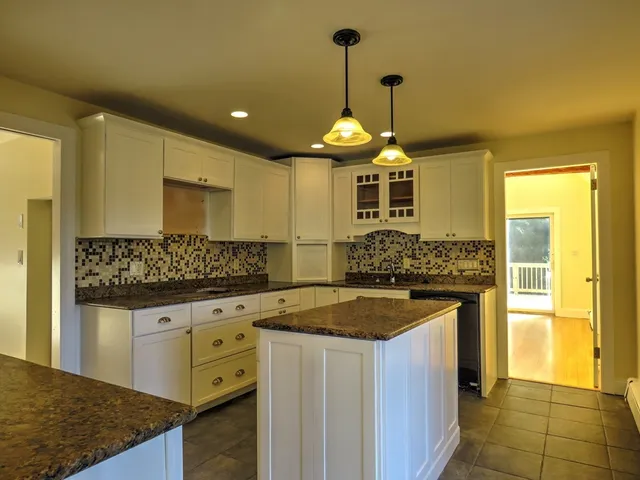 a kitchen with stainless steel appliances granite countertop a stove and cabinets