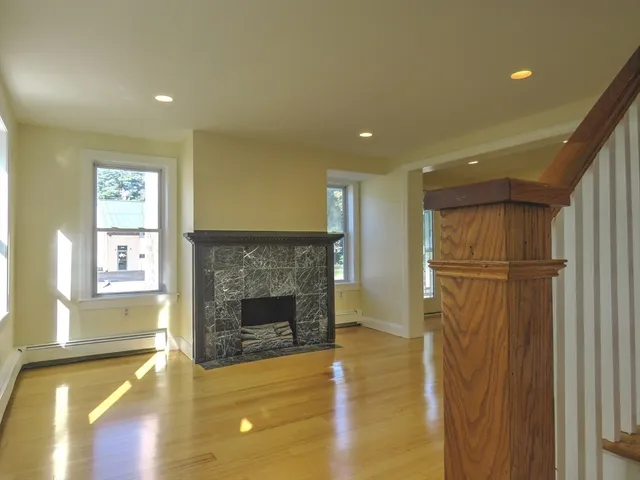 a view of a livingroom with a fireplace and window