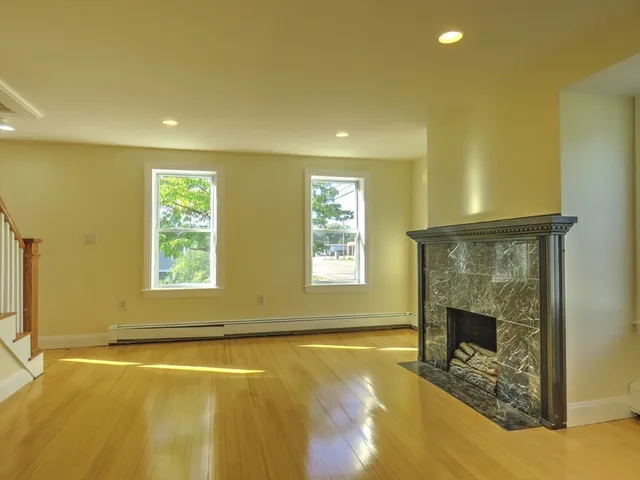 an empty room with a fireplace and windows
