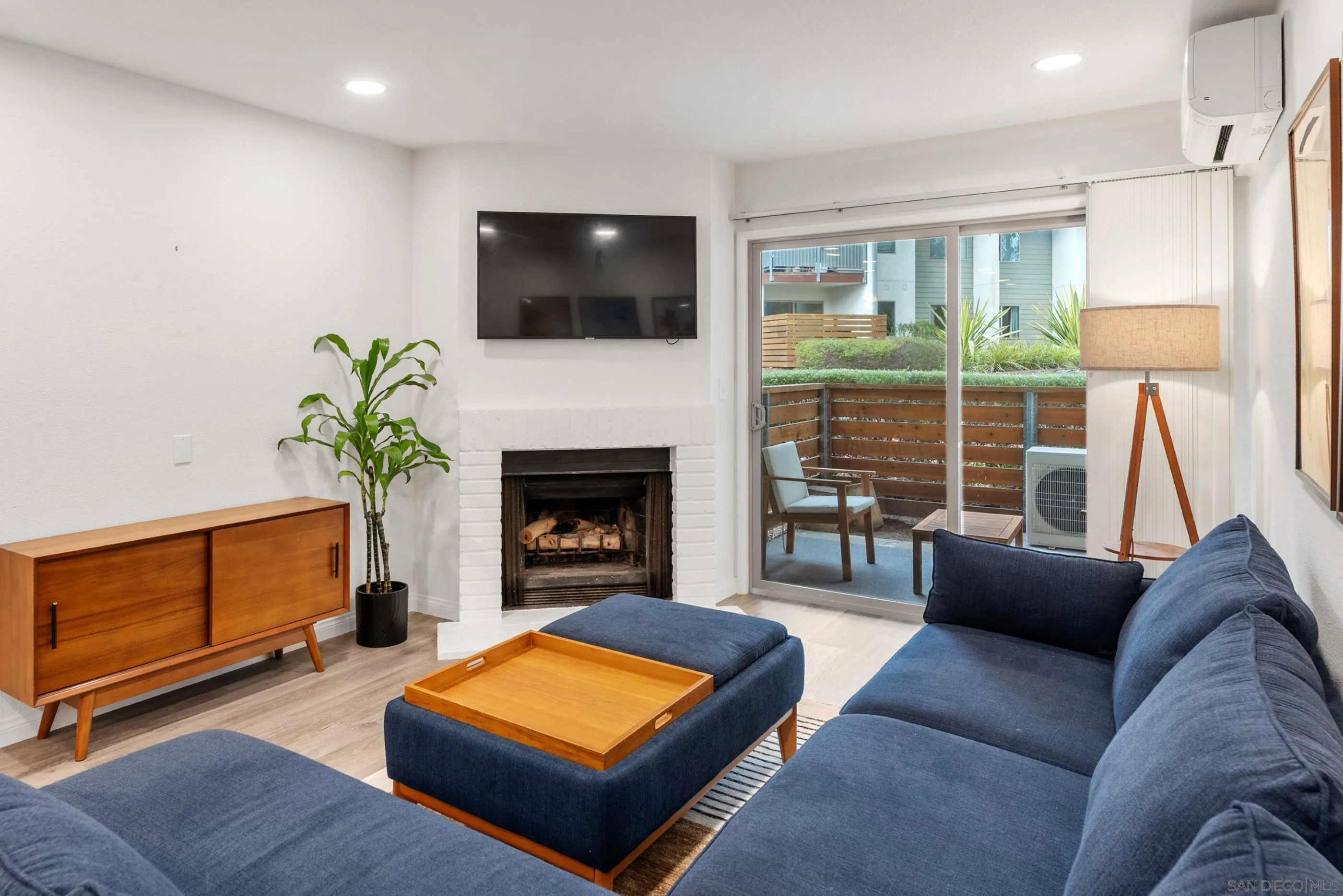 1810 South El Camino Real, Unit 101 Encinitas, CA 92024 - Photo 4 of 39 a living room with furniture a flat screen tv and a fireplace