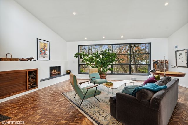 a living room with furniture a fireplace and a large window