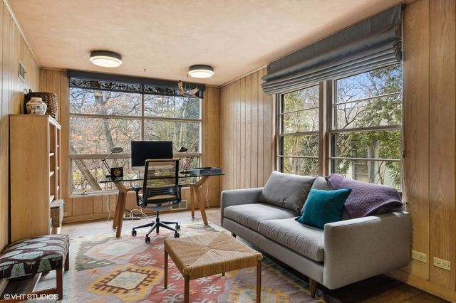a living room with furniture a large window and a flat screen tv