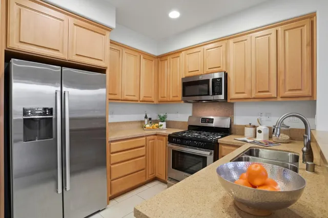 a kitchen with stainless steel appliances granite countertop a stove a sink and a microwave