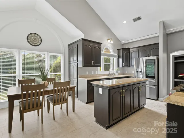 a kitchen with stainless steel appliances granite countertop a stove and a table