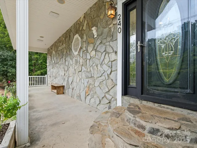 a view of a entryway door with brick wall and potted plants