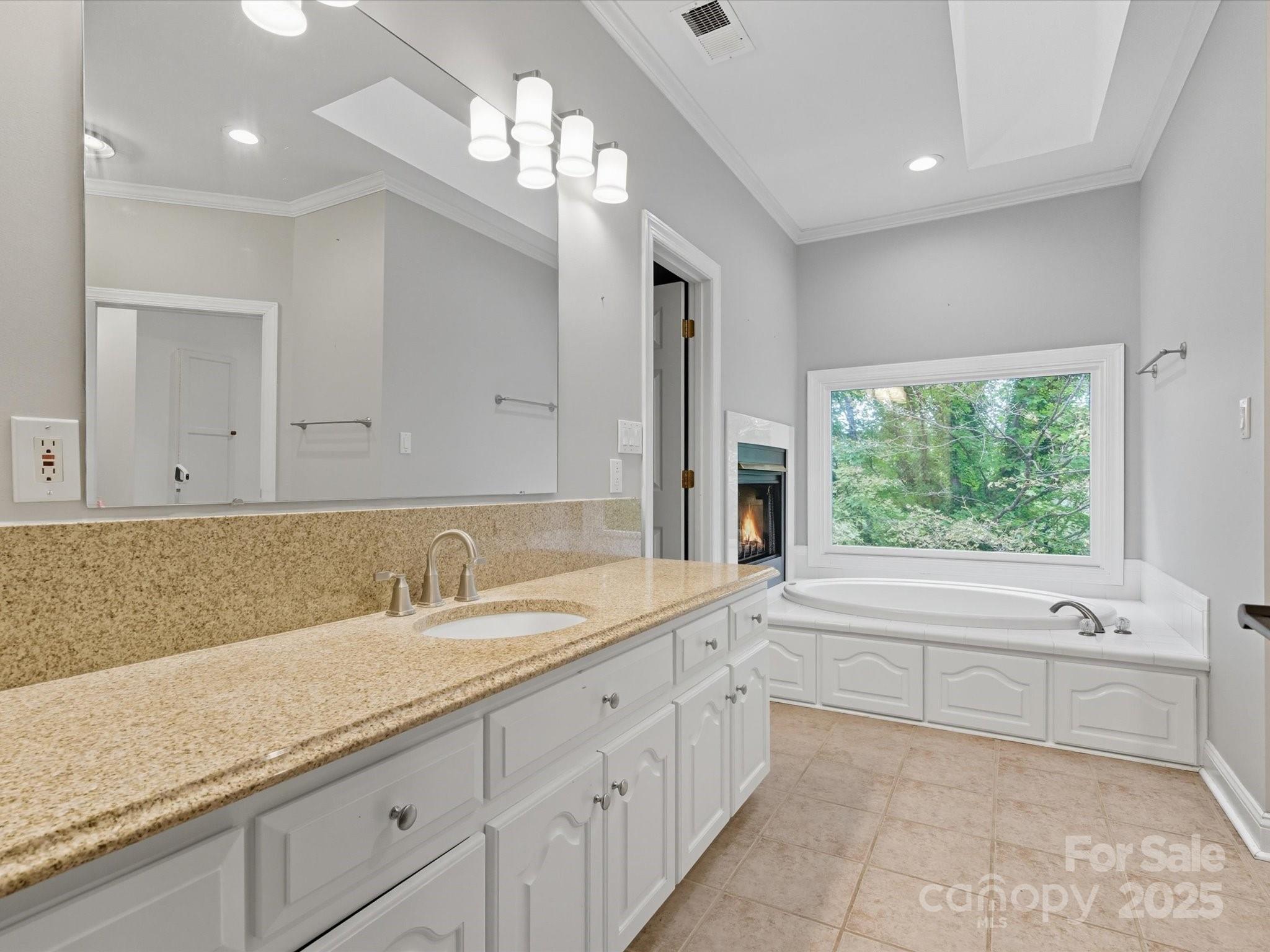 240 Petty Road Gastonia, NC 28056 - Photo 23 of 48 a bathroom with a sink a large mirror and a bathtub next to a window