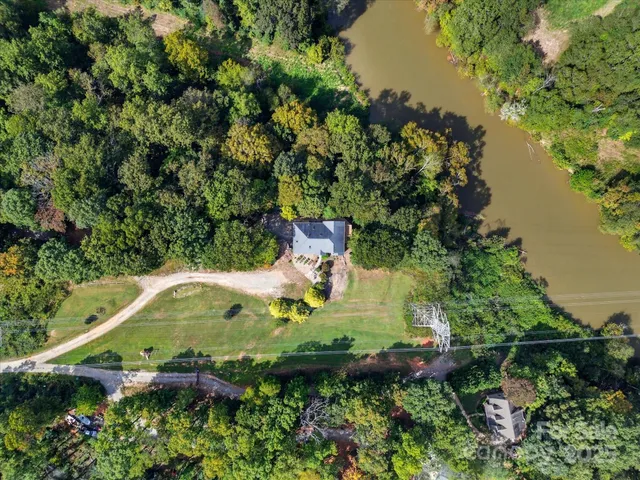 an aerial view of residential house with outdoor space and trees all around
