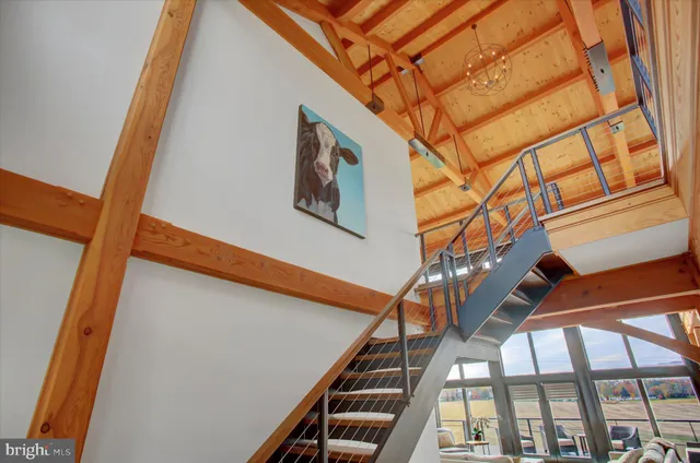 a living room with stainless steel appliances kitchen island granite countertop a table chairs and a wooden cabinets