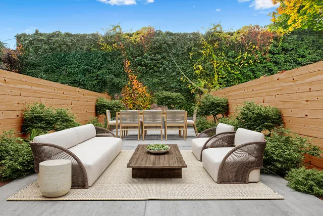 a view of a patio with couches table and chairs and potted plants