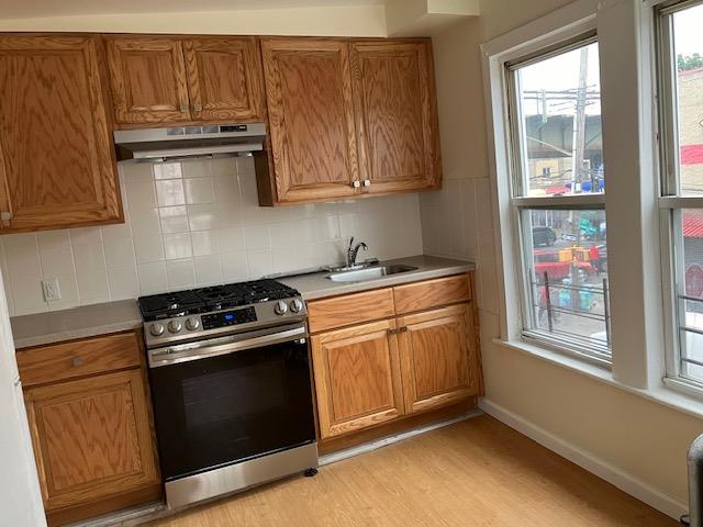 3925 White Plains Road, Unit 4A Bronx, NY 10466 - Photo 3 of 4 a kitchen with stainless steel appliances granite countertop a stove a sink and a microwave