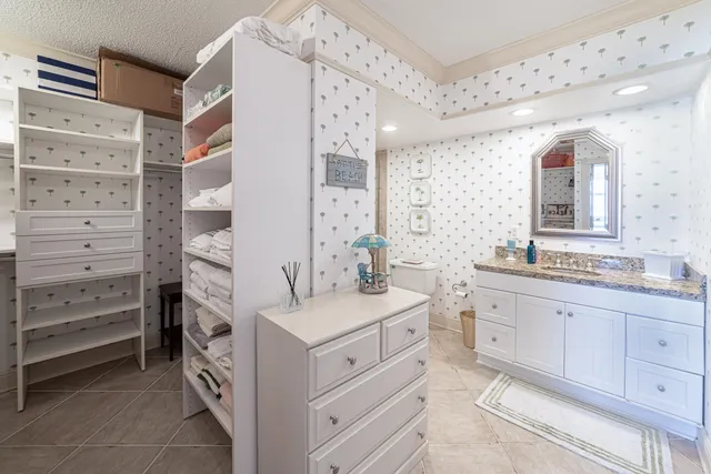 a bathroom with a granite countertop sink a toilet a mirror and shower