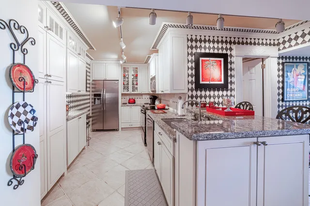 a kitchen with granite countertop a sink stainless steel appliances and cabinets