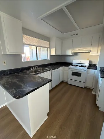 a kitchen with granite countertop a stove and a sink