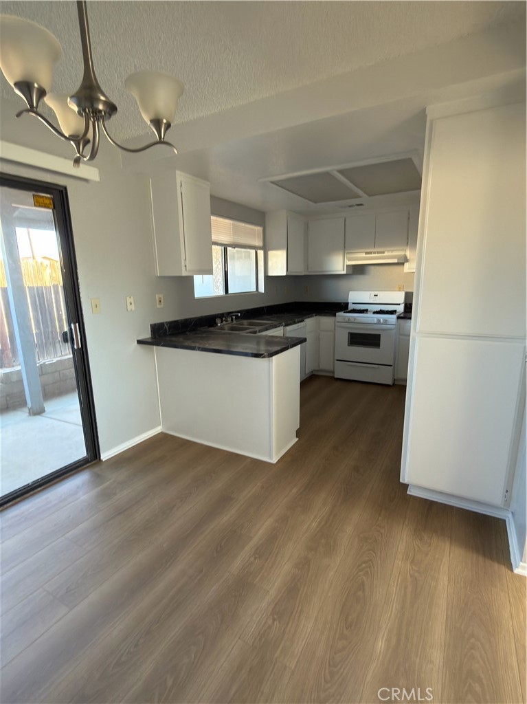 10547 Cochiti Road Apple Valley, CA 92308 - Photo 5 of 10 a kitchen with stainless steel appliances a sink a stove a refrigerator and cabinets