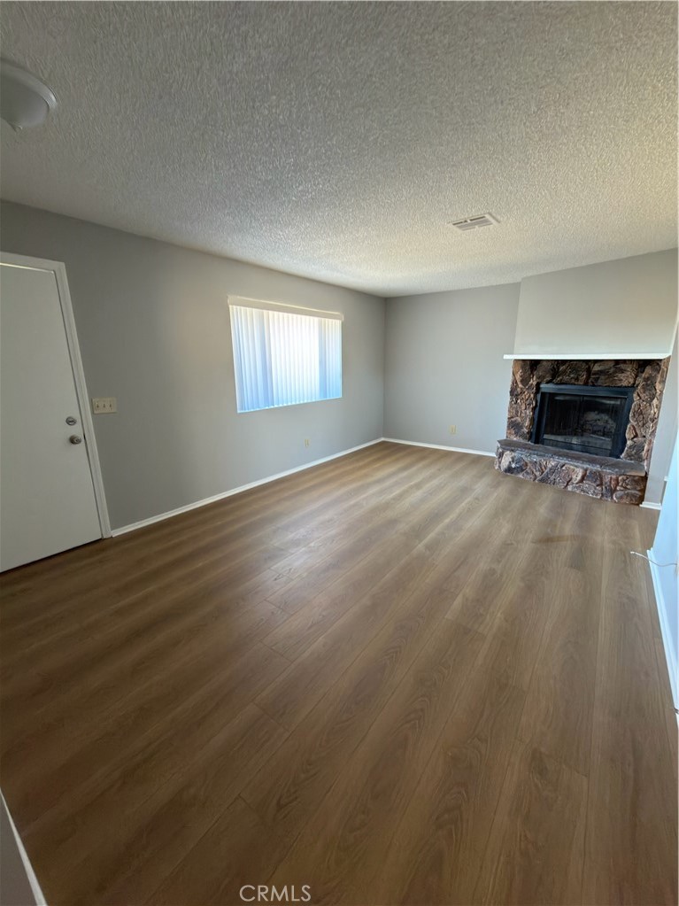 10547 Cochiti Road Apple Valley, CA 92308 - Photo 8 of 10 an empty room with wooden floor and windows