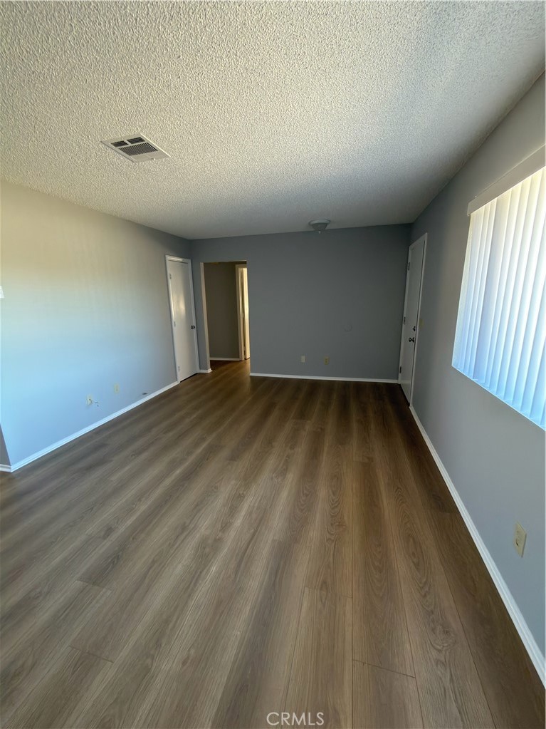 10547 Cochiti Road Apple Valley, CA 92308 - Photo 9 of 10 wooden floor in an empty room with a window