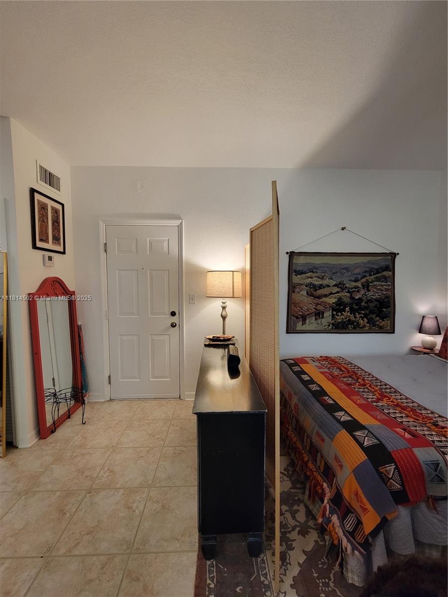 359 Meridian Avenue, Unit A103 Miami Beach, FL 33139 - Photo 13 of 22 a bedroom with a bed and a mirror