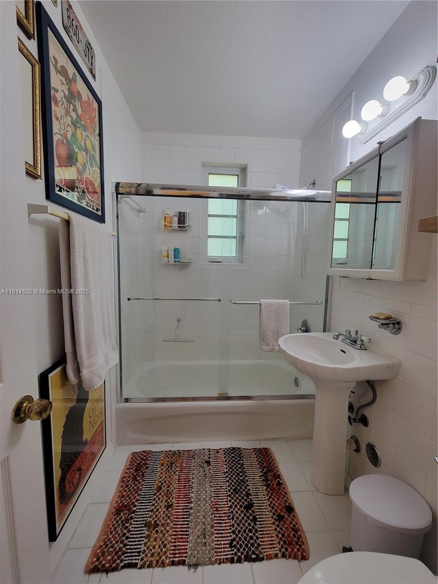 359 Meridian Avenue, Unit A103 Miami Beach, FL 33139 - Photo 16 of 22 a bathroom with a sink toilet and shower