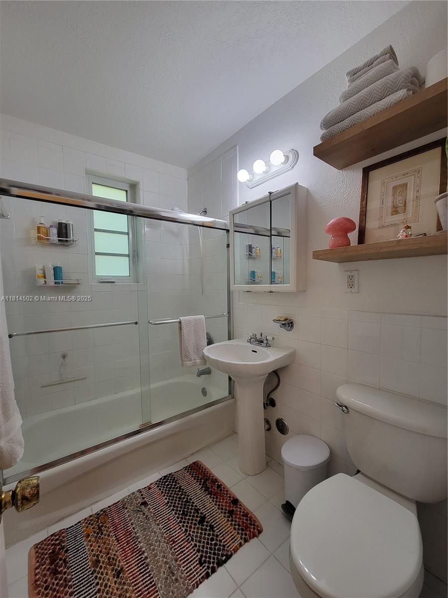 359 Meridian Avenue, Unit A103 Miami Beach, FL 33139 - Photo 17 of 22 a bathroom with a sink a toilet and shower