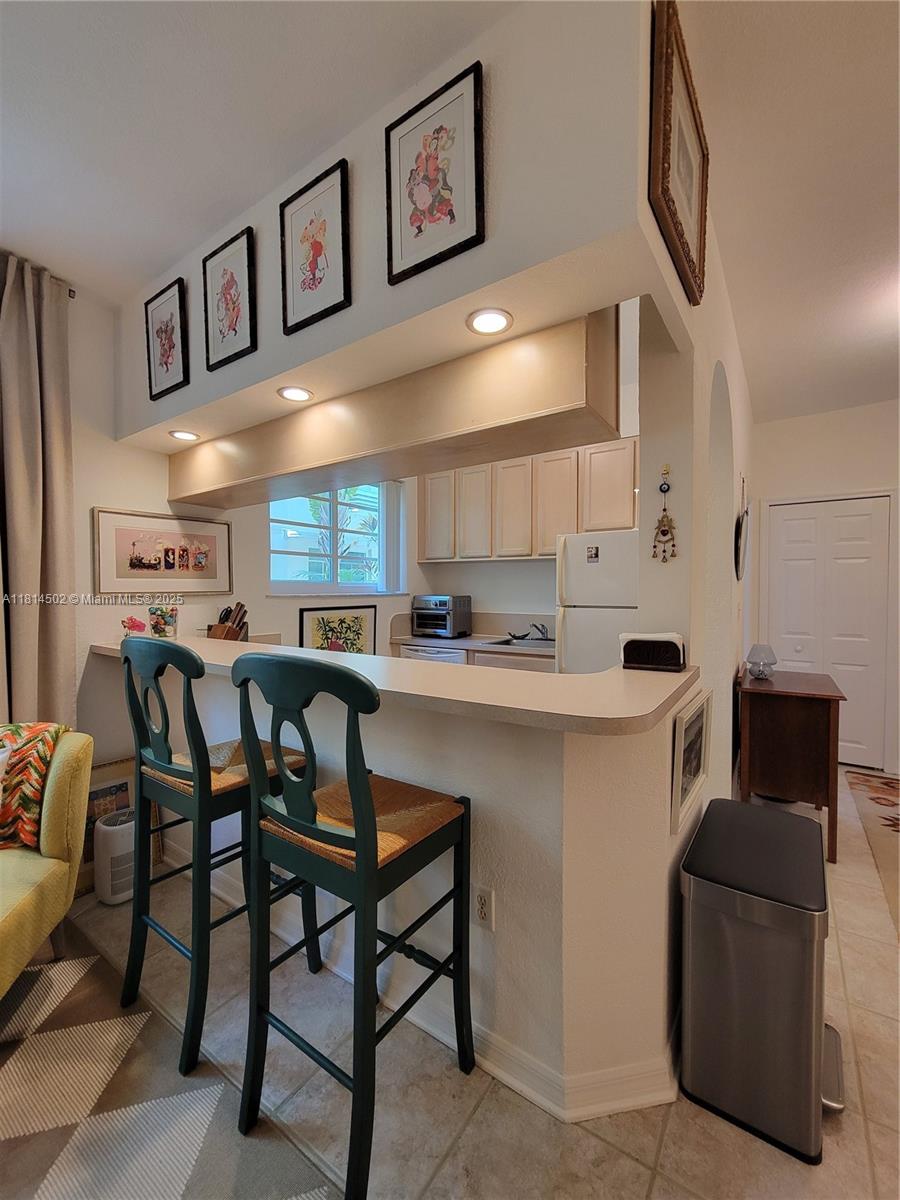359 Meridian Avenue, Unit A103 Miami Beach, FL 33139 - Photo 3 of 22 a kitchen with a cabinets and chairs