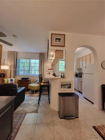 a living room with couches and kitchen view with wooden floor