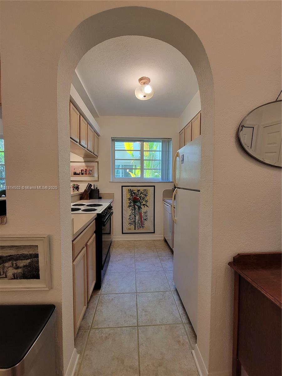 359 Meridian Avenue, Unit A103 Miami Beach, FL 33139 - Photo 8 of 22 a kitchen with stainless steel appliances granite countertop a refrigerator and a stove