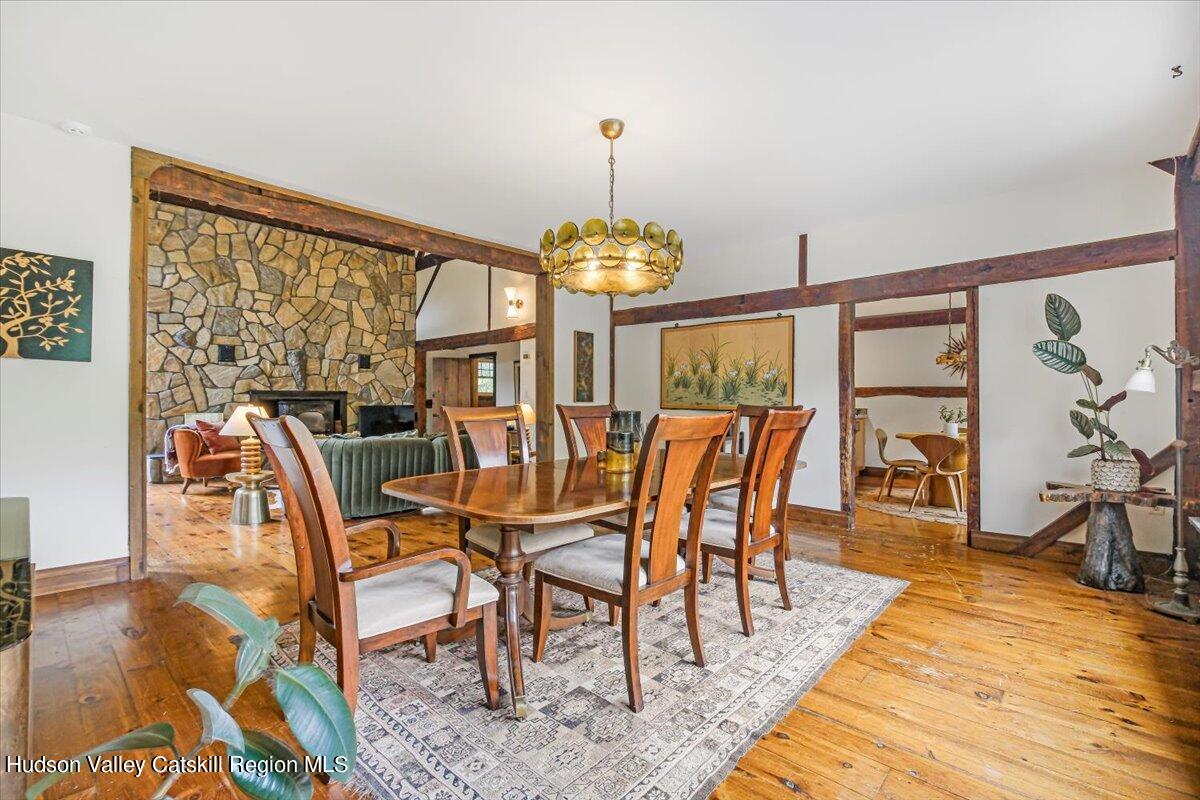 5 Longview Road Clinton, NY 12514 - Photo 11 of 44 a dining room with wooden floor a chandelier a glass table and chairs