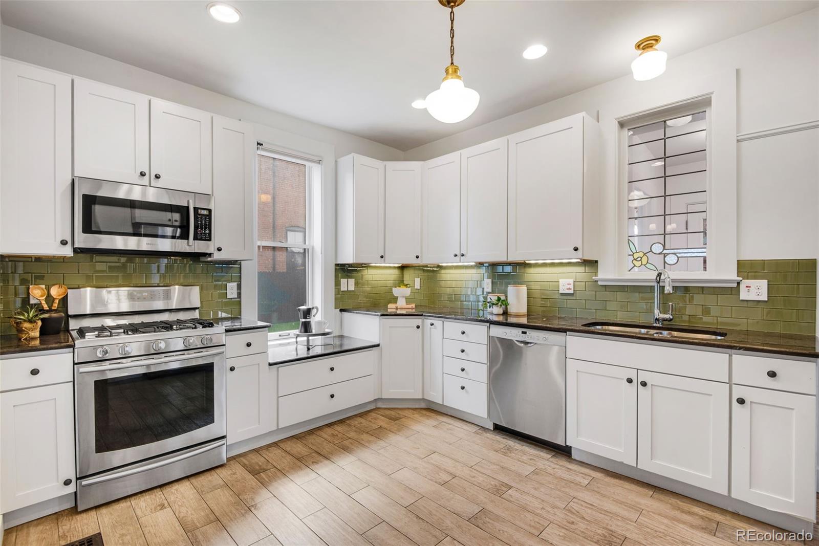 2815 Curtis Street Denver, CO 80205 - Photo 11 of 48 a kitchen with cabinets appliances a sink and a window