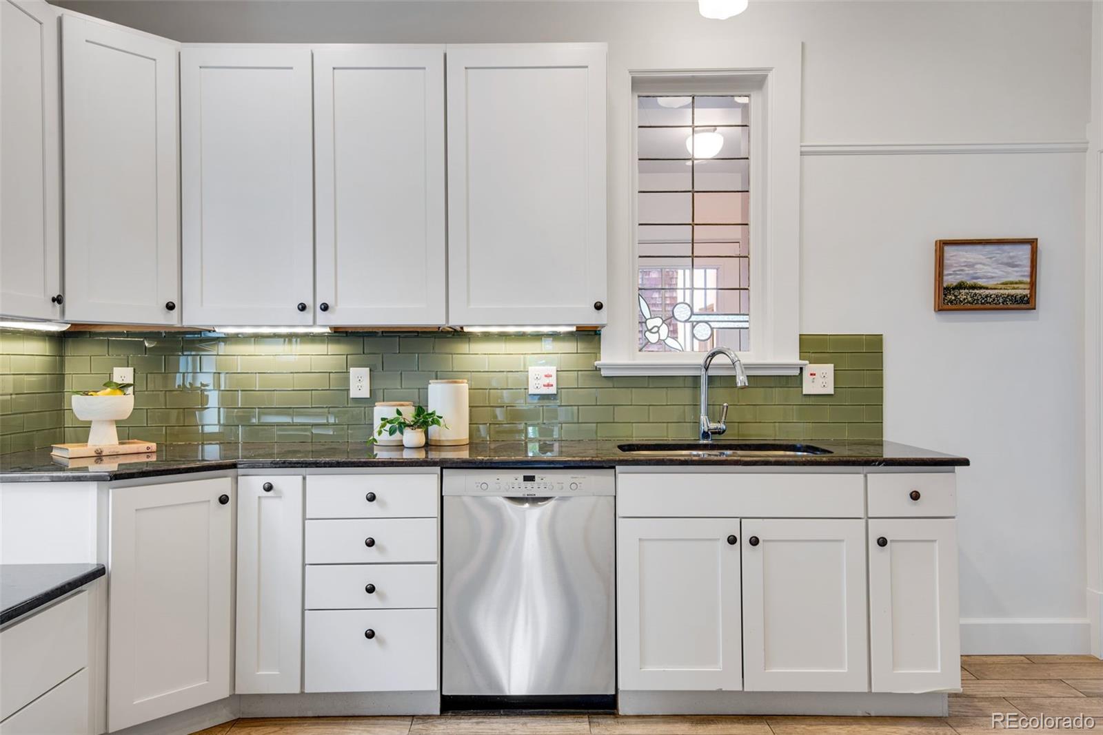 2815 Curtis Street Denver, CO 80205 - Photo 12 of 48 a kitchen with granite countertop a sink and cabinets
