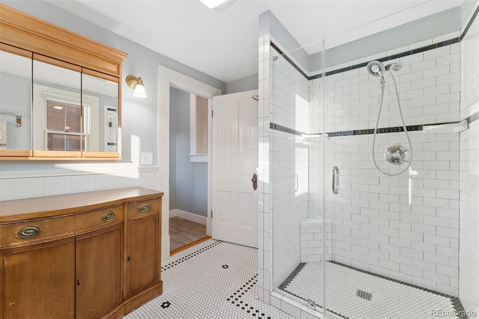 2815 Curtis Street Denver, CO 80205 - Photo 16 of 48 a bathroom with a shower and a sink a mirror