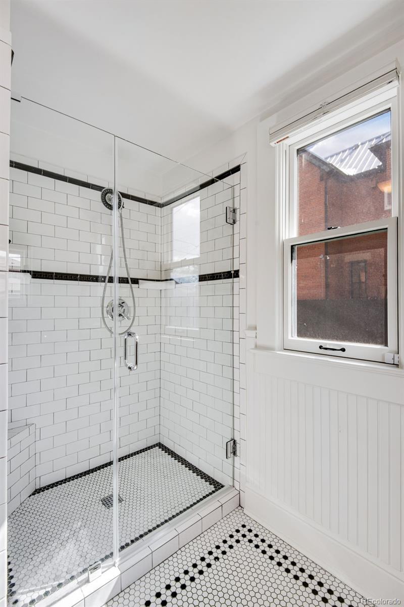 2815 Curtis Street Denver, CO 80205 - Photo 17 of 48 a bathroom with a shower and a glass door