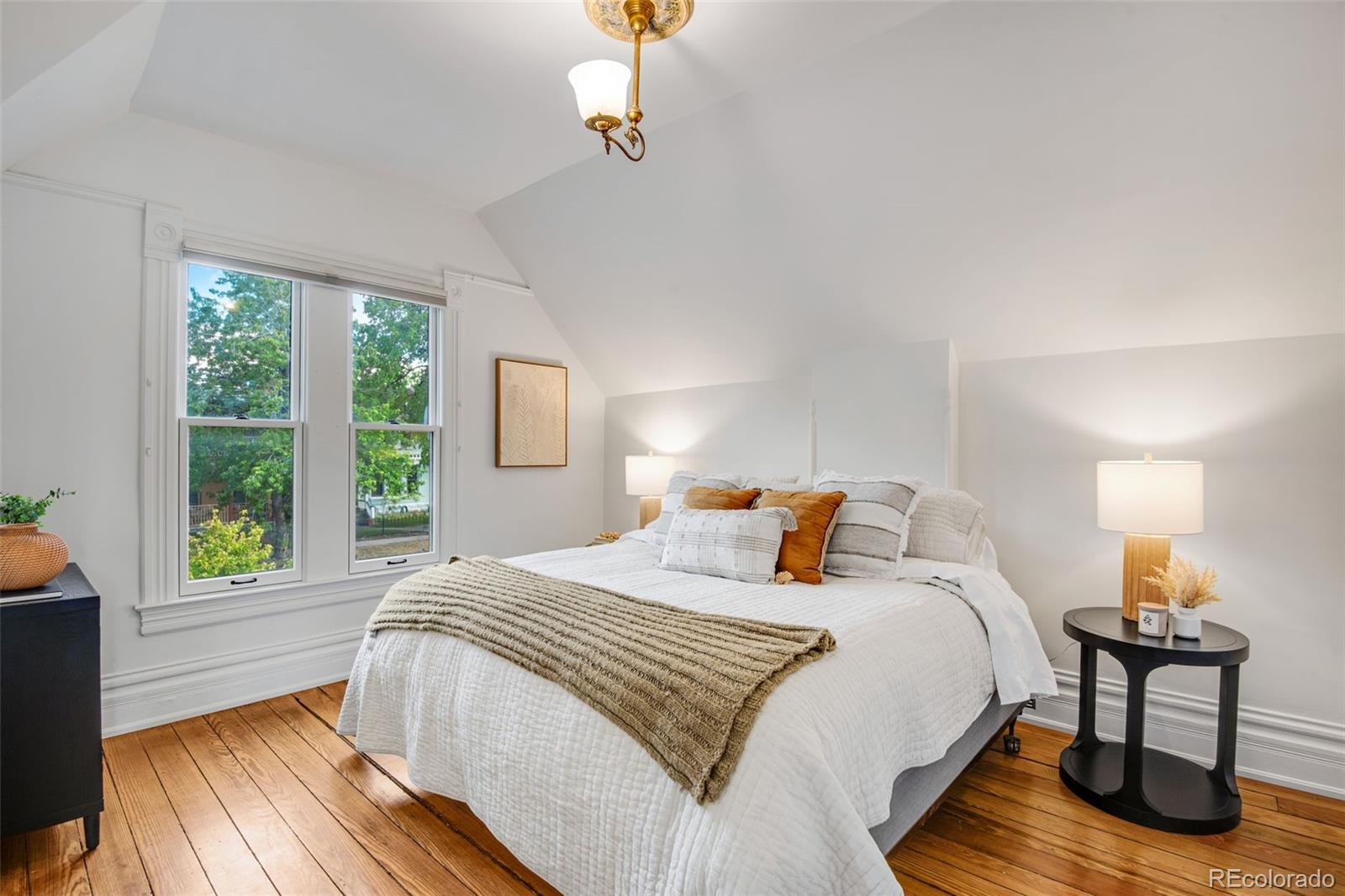 2815 Curtis Street Denver, CO 80205 - Photo 20 of 48 a bedroom with a bed a window and lamps
