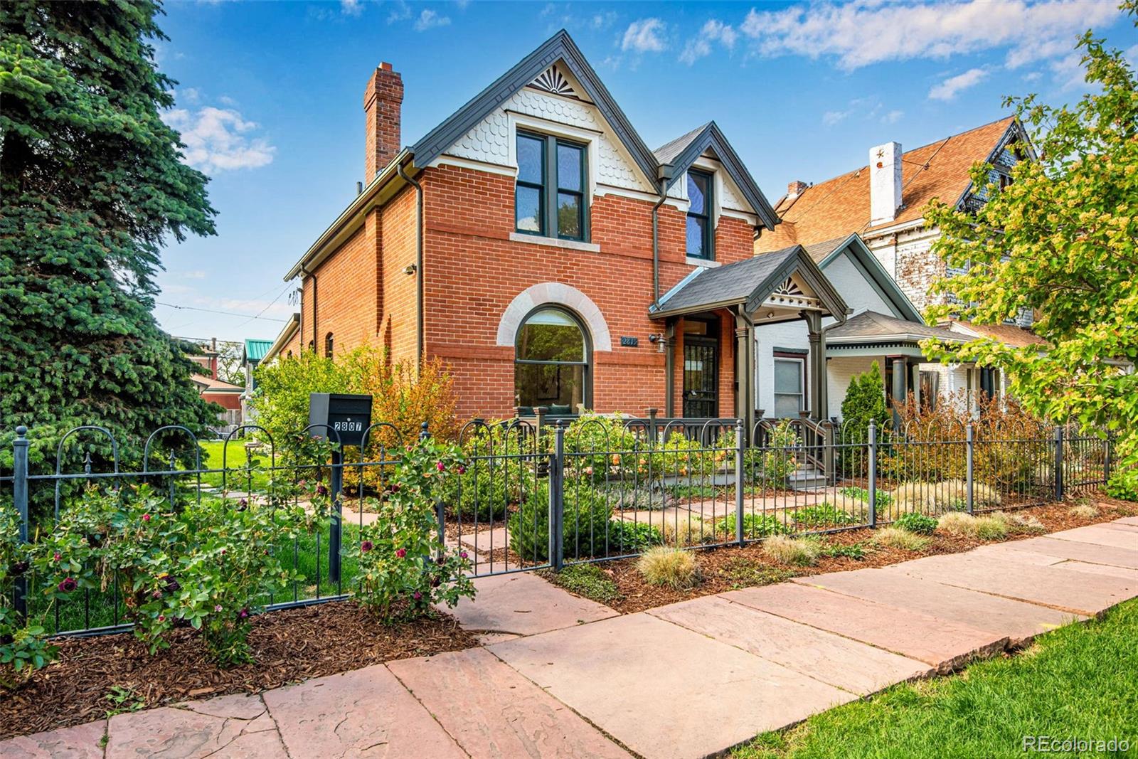 2815 Curtis Street Denver, CO 80205 - Photo 2 of 48 a front view of a house with a garden