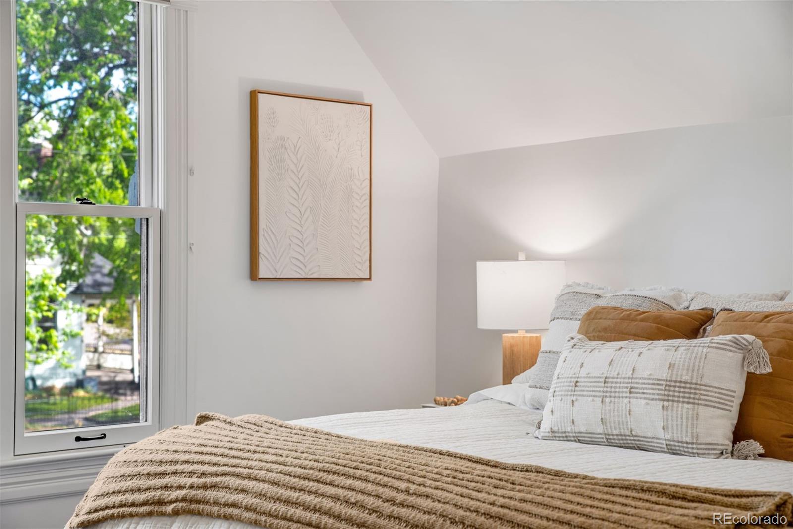2815 Curtis Street Denver, CO 80205 - Photo 21 of 48 a bedroom with a bed and a window