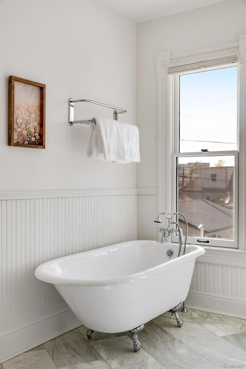 2815 Curtis Street Denver, CO 80205 - Photo 25 of 48 a bathroom with a bathtub and window