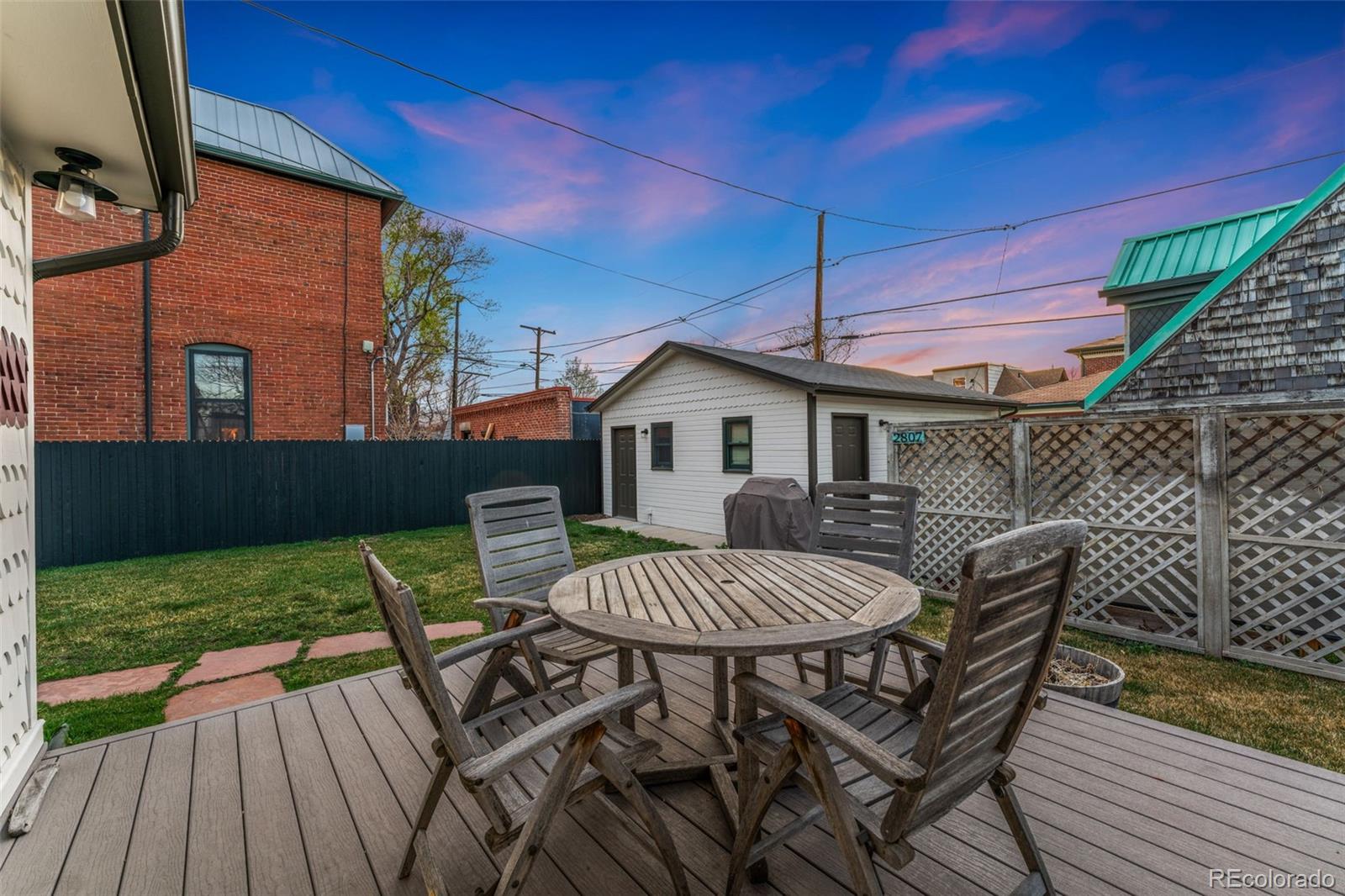 2815 Curtis Street Denver, CO 80205 - Photo 28 of 48 a view of a patio with table and chairs with wooden floor and fence
