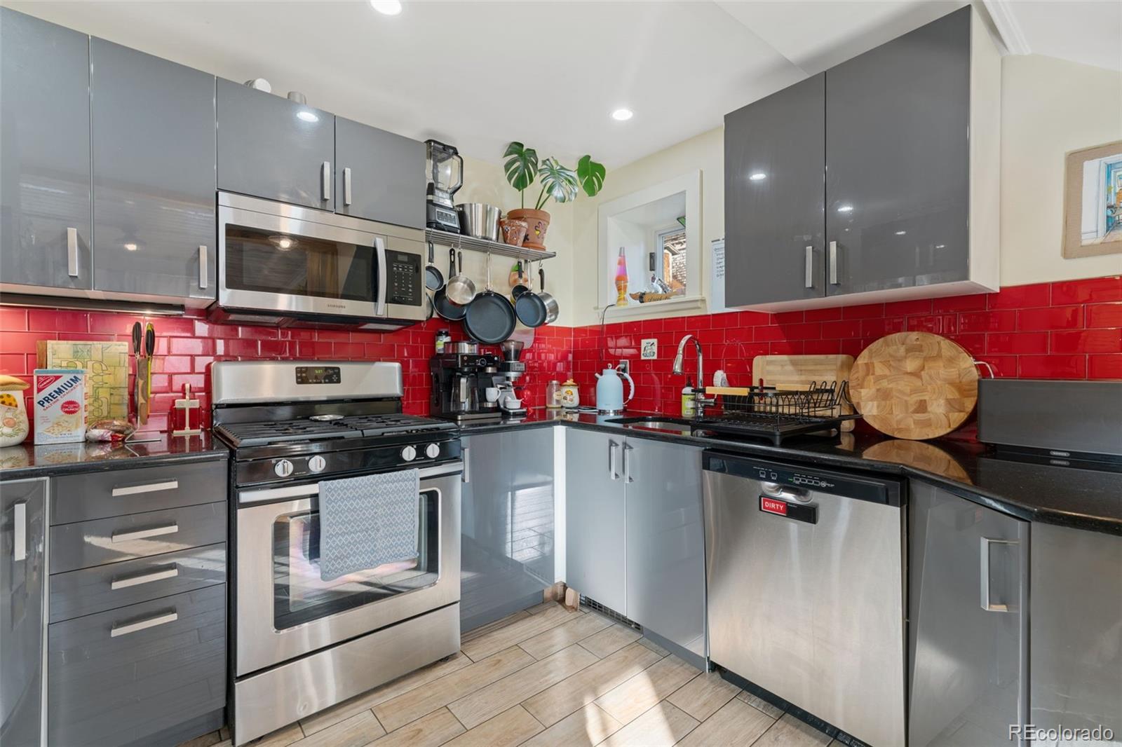 2815 Curtis Street Denver, CO 80205 - Photo 36 of 48 a kitchen with stainless steel appliances granite countertop a stove a sink and a microwave