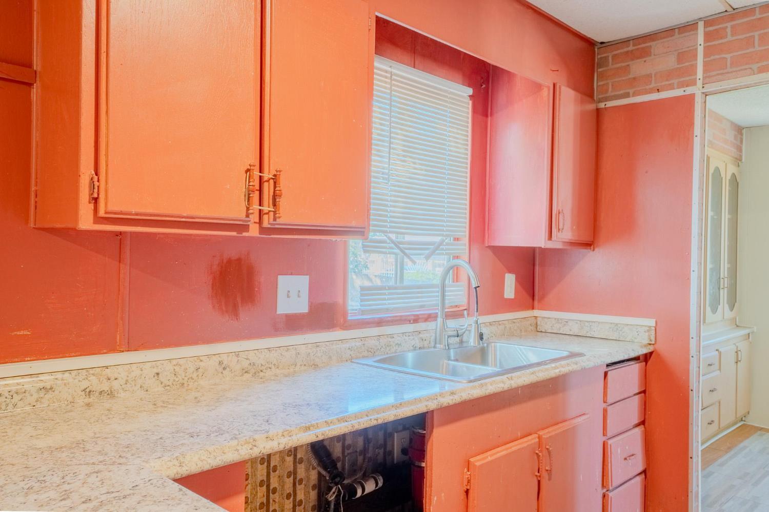 108 West Merced Street Avenal, CA 93204 - Photo 11 of 11 a kitchen with stainless steel appliances granite countertop a sink and a wooden cabinets