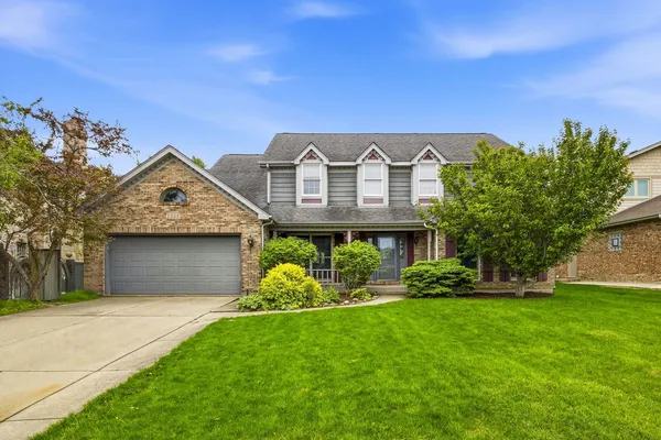 a front view of a house with a garden and yard