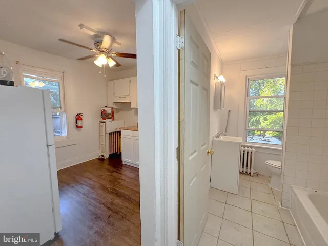 a view of a kitchen with wooden floor and a refrigerator