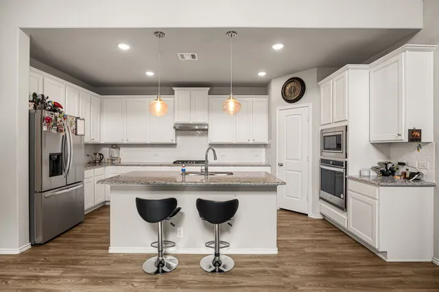 a kitchen with kitchen island cabinets and stainless steel appliances