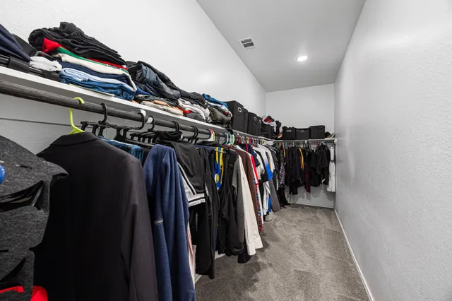 a view of walk in closet with clothes
