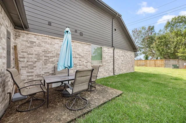 a view of a backyard with table and chairs and wooden fence